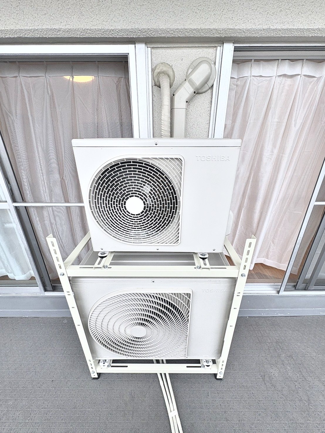 ベランダに2段置きで据え付けた室外機